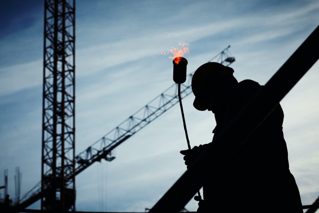 a worker silhouette holding a torch in construction site